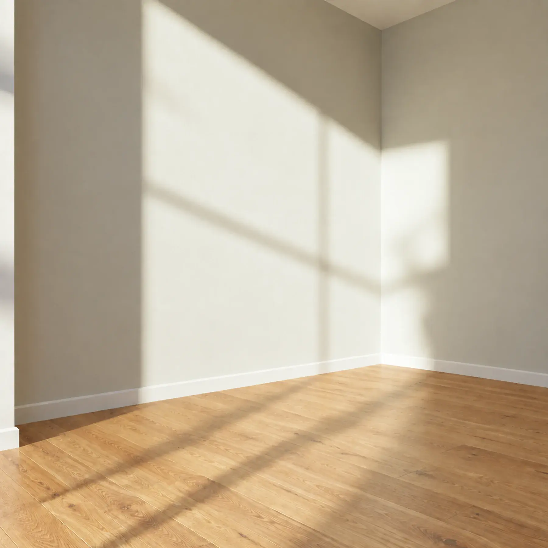 Interior styling concept: an empty sunlit room with pale walls and a timber floor, created by removing furnishings from the furnished photograph.